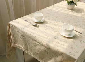 Close-up of floral cotton linen tablecloth with delicate lace edge and detailed stitching