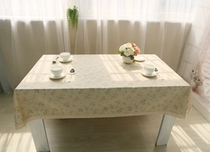 Close-up of floral linen tablecloth with beige lace trim and delicate flower pattern