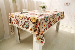 Close-up of bohemian linen tablecloth featuring mandala patterns and beige lace edges