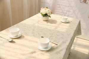 Close-up of floral tablecloth with elegant white lace edge and cozy afternoon tea scene