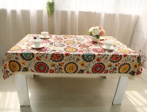 Close-up of bohemian linen tablecloth with ethnic floral patterns and white crochet lace edge