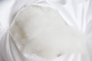 Macro shot of fluffy white PP cotton filling and smooth fabric texture for pillow core