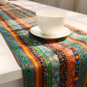 Ethnic bohemian table runner with colorful geometric patterns on a white table