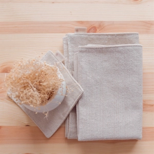 Natural linen cotton placemats and napkins on wood background with ceramic vase