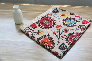 Detail of bohemian mandala tablecloth with intricate white crochet lace edge on wood