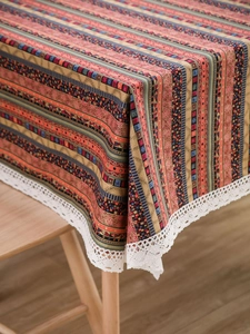 Close-up of bohemian ethnic tablecloth featuring vibrant stripes and white lace edges