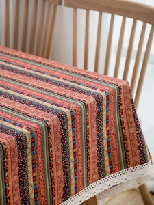 Close-up of Bohemian cotton linen tablecloth with ethnic stripes and white lace trim