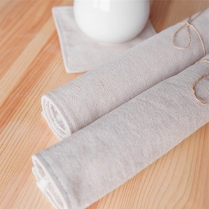 Natural linen placemats and coasters set with rustic twine wrap on a wooden table