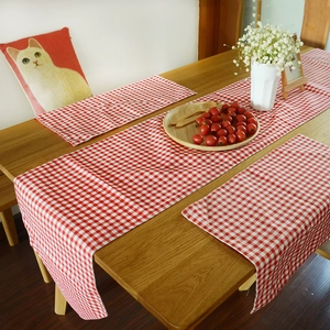 Red gingham cotton linen table runner and placemat set on a rustic wooden table
