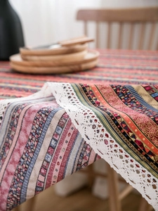 Detail of bohemian cotton linen tablecloth with ethnic stripes and white lace trim
