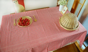 Detail of red gingham cotton linen tablecloth with delicate white floral lace edges