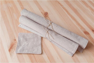 Detail of eco-friendly linen placemats and coasters on light wood background