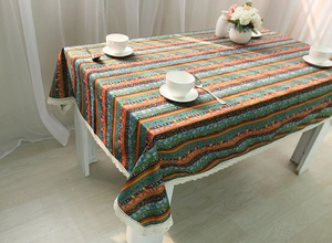 Detailed close-up of colorful Bohemian striped linen tablecloth with white lace edges