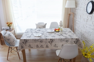Detailed view of linen tablecloth with vintage butterfly prints and lace edge details