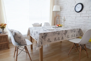 Close-up of beige table linen with vintage butterfly prints and white lace edges