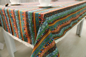 Detailed shot of ethnic bohemian tablecloth with intricate white lace border and stripes