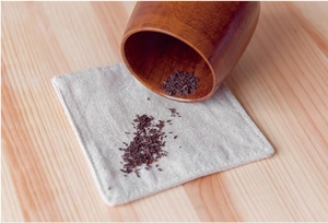 Close-up of natural linen coaster with stitched edges and rustic texture for dining decor