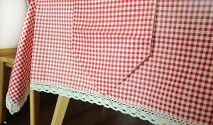 Close-up of red and white checkered tablecloth featuring vintage off-white lace borders