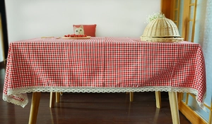 Detailed view of red and white checkered tablecloth with delicate white lace edge finish