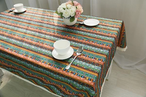 Detail of colorful Bohemian cotton linen tablecloth with elegant white lace edge decor