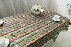 Close-up of Bohemian cotton linen tablecloth with colorful stripes and white lace edge