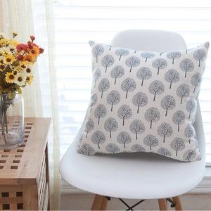 Modern minimalist beige linen cushion cover with grey tree pattern on a white chair