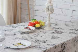 Close-up of cream rectangular tablecloth with vintage butterfly and script patterns
