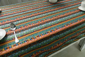 Detail of bohemian cotton linen tablecloth with colorful mosaic stripes and lace edges