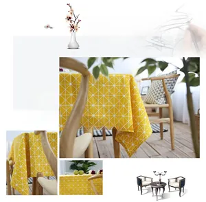 Detail of yellow cotton linen tablecloth featuring white geometric grid pattern texture