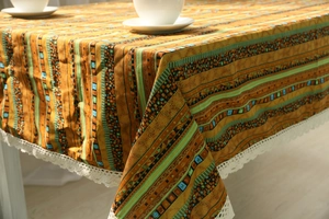 Detail of bohemian cotton linen tablecloth with orange stripes and white lace edges