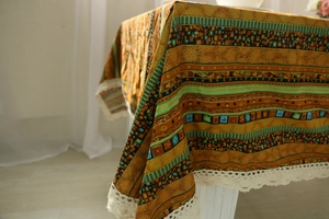 Close-up of bohemian linen tablecloth with ethnic patterns and delicate lace trim detail