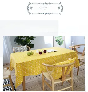 Detail of yellow and white checkered linen tablecloth with a matching cushion on a table