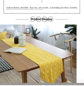 Detail of yellow cotton linen table runner with white geometric triangle patterns