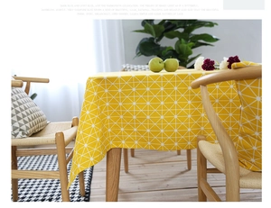 Detail of yellow geometric linen tablecloth with white grid lines in a bright dining room