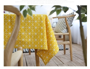 Detailed view of yellow cotton linen tablecloth with white geometric grid patterns