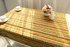 Detail of bohemian cotton linen tablecloth with orange geometric patterns and lace edge