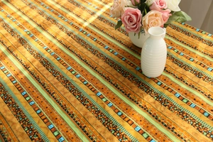 Detailed view of bohemian style cotton linen tablecloth with orange and turquoise stripes