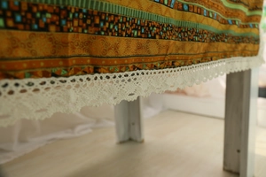 Close-up of bohemian geometric table cloth with intricate white crochet lace edge details
