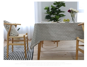 Detailed close-up of grey and white herringbone pattern on linen fabric tablecloth