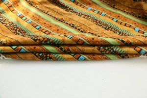 Close-up detail of bohemian linen tablecloth with ethnic geometric patterns in orange