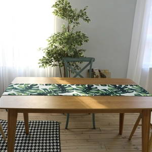 Nordic style table runner with green monstera leaves pattern on white fabric