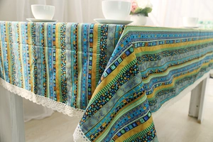 Close-up of bohemian linen tablecloth featuring colorful patterns and lace trim