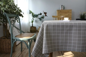 Detail view of grey checkered cotton linen tablecloth with elegant draped fabric texture