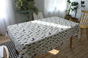 Detail of linen-cotton tablecloth with forest elk pattern and artistic typography