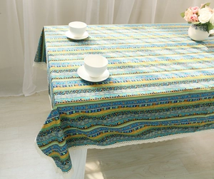 Close-up of bohemian linen tablecloth featuring colorful stripes and white lace edges