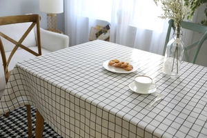 Dettaglio di una tovaglia minimalista a quadretti bianchi e neri in cotone e lino sul tavolo