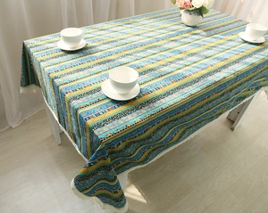 Detail of bohemian cotton linen tablecloth with colorful stripes and white lace edges