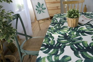 Gros plan d'une nappe imperméable à motif de feuilles de monstera vertes sur table en bois