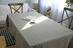 Macro view of grey linen tablecloth with white grid pattern on a long dining table