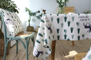 Detail of linen tablecloth with forest deer pattern and scenic home decor background